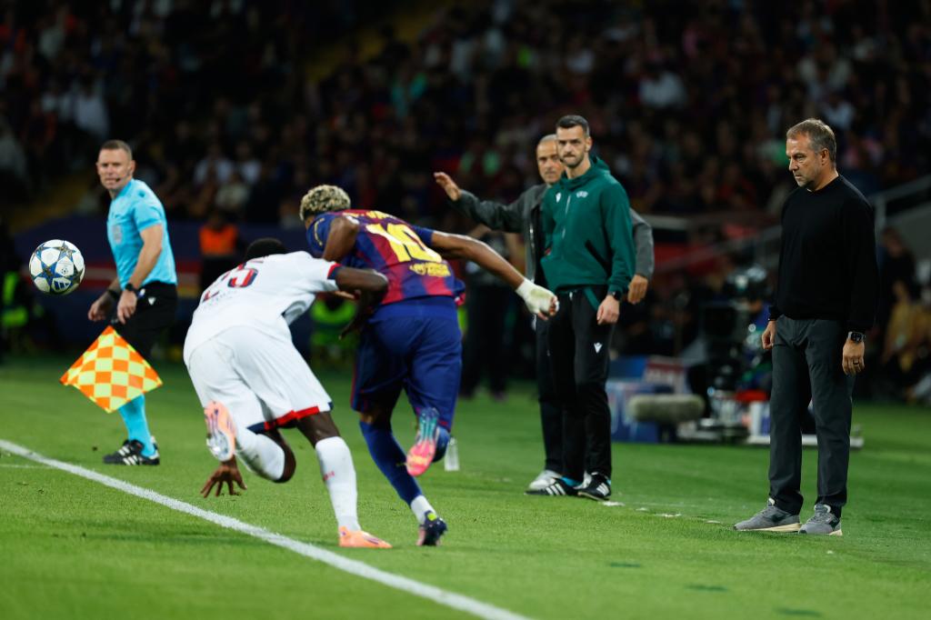 Barcelona's head coach Hansi Flick, right, looks PSG's Nuno Mendes, left, duels for the ball with Barcelona's Lamine Yamal during the Champions League opening phase soccer match between Barcelona and Paris Saint-Germain at the Lluis Companys Olympic Stadium in Barcelona, Spain, Wednesday, Oct. 1, 2025. (AP Photo/Joan Monfort)
